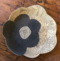 a black and white plate sitting on top of a wooden table