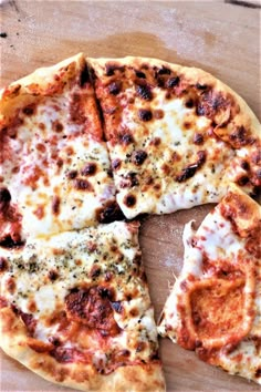 the pizza is cut into four pieces and has cheese on it, along with other toppings