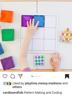 a child's hands on top of a play mat with colored blocks and shapes