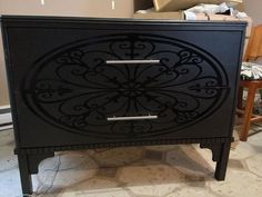 a black cabinet sitting on top of a tiled floor