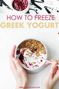 two hands holding a spoon over a bowl of yogurt with berries and granola