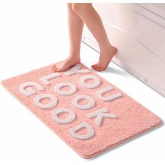 a pink door mat with the words cookbook on it and a woman's legs