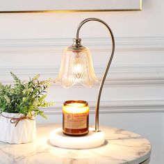 a table with a candle on it next to a potted plant