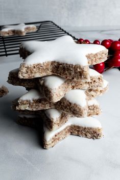 a stack of cookies sitting on top of a table covered in frosting next to christmas decorations