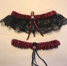 two red and black garters with ribbons attached to them on a white surface