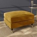 a yellow footstool sitting on top of a floor next to a table and chair