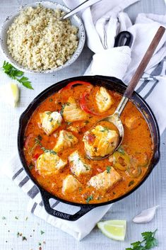 a pan filled with chicken and rice next to a bowl of rice on top of a table