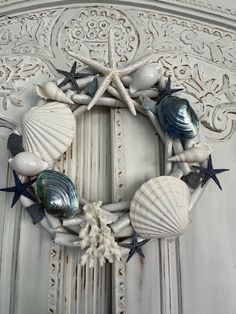 a wreath made out of seashells and starfish is hanging on the door