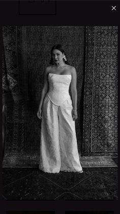 a black and white photo of a woman in a strapless dress with wide pants