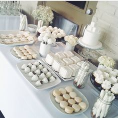 there are many desserts on the table ready to be eaten at this wedding reception