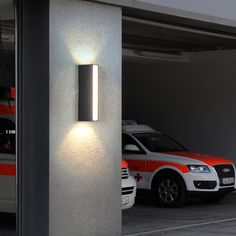 two police cars parked in an underground parking garage with the lights on and emergency vehicles behind them