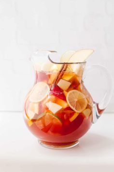 a pitcher filled with liquid and sliced fruit