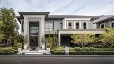 a large house with lots of trees and bushes in front of the entrance to it