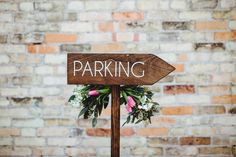 a wooden sign with flowers on it that says dinner and catering next to a brick wall