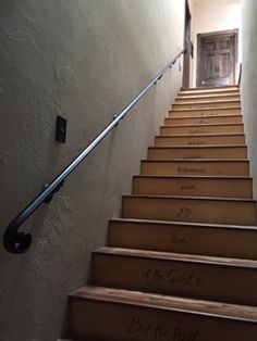 a set of stairs with writing on the steps leading up to an open door at the top