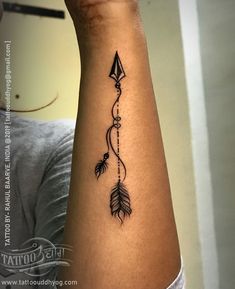 a woman's arm with an arrow and feather tattoo on the left side of her arm