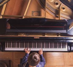 a young boy playing the piano from above