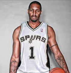 a man holding a basketball in his right hand and wearing a jersey with the number 1 on it