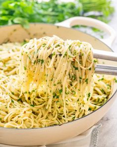 a large pot filled with pasta and parmesan cheese being stirred by a ladle