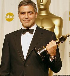 a man in a tuxedo holding an award