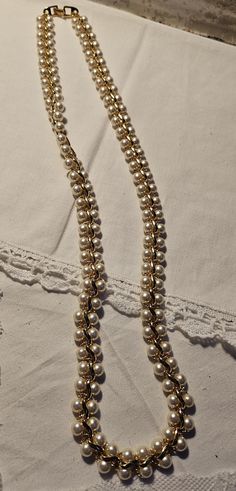 This necklace has double pearl strands with gold scroll pattern between. This has a simple gold clasp.  The Napier Company got its start in North Attleboro, Massachusetts 1878, under the name of The E. A. Bliss Co., manufacturing gilt men's watch chains. The company ceased operations in 1999 and at that time considered the oldest fashion jewelry house in America.  No issues.  24" Elegant Formal Pearl Necklace With Gold Beads, Gold Double Strand Pearl Necklace For Formal Occasions, Elegant Double Strand Gold Pearl Necklace, Formal Gold Double Strand Pearl Necklace, Elegant Gold Double Strand Pearl Necklace, Elegant Gold Metal Pearl Necklace, Gold Double Strand Pearl Necklace For Wedding, Elegant Gold Pearl Necklace, Classic Gold Pearl Necklace For Party