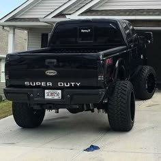 a black truck parked in front of a house