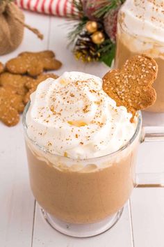 two mugs filled with hot chocolate and marshmallows on a white table