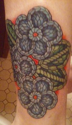 a close up of a person's leg with flowers on it