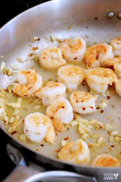 shrimp and rice cooking in a skillet on top of the stovetop with seasoning