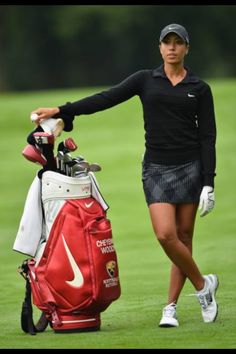 a woman holding a golf club and bag