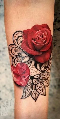 a rose tattoo on the leg with lace and red flowers in it's center