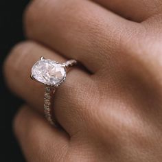 a woman's hand with a diamond ring on top of her finger and an engagement band