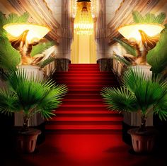 a red carpeted staircase leading up to a chandelier with two lamps on it