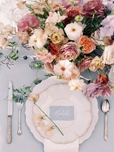 a table setting with flowers and silverware