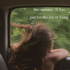 a woman sitting in the back seat of a car with her hair blowing in the wind