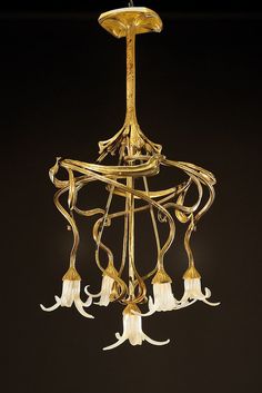 a gold chandelier with white flowers hanging from it's center and four lights on each side