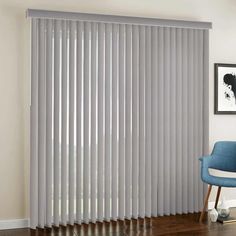 a blue chair sitting in front of a window with vertical blinds on the windowsill