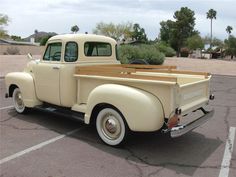 an old pick up truck parked in a parking lot