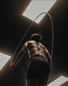 a woman is performing aerial acrobatic exercises on a rope in the dark