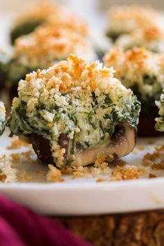 spinach stuffed mushrooms on a plate with text overlay that reads spinach stuffed mushrooms