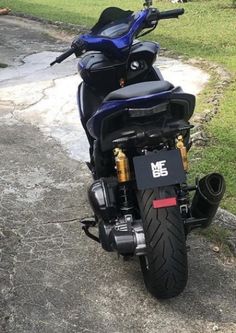 a black and blue motorcycle parked on top of a road next to grass covered field