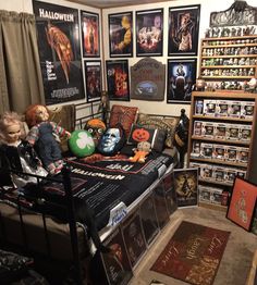 a room filled with lots of halloween decorations and pictures on the wall above the bed