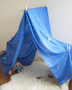 a blue tent sitting on top of a white rug next to a stuffed animal toy