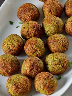 a white plate topped with meatballs and garnished with parsley on top