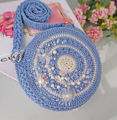 👜GENERAL FEATURES👜  FeyZolfey blue women's purse is produced from 100% polypropylene yarn. The lining inside this beaded bag is floral cotton fabric. The overall dimensions of this crochet round purse are 22x22x4cm. This small shoulder bag has one knit (98cm) shoulder strap. It also has a magnetic snap closure system. It does not contain chemicals that may affect human health.  ⭐A UNIQUE PIECE⭐  FeyZolfey beaded clutch purse has a magnificent look thanks to its unique design. Circle bags, which have multiple uses, can be used daily, on the beach, at an invitation or in areas such as school. Due to the lining inside, necessary items such as phone, wallet, notepad can be carried. It is the perfect bag for events. You can show your value to your loved ones by gifting this crossbody purse on Blue Crochet Bag For Gift, Blue Crochet Shoulder Bag Gift, Blue Crochet Shoulder Bag For Gift, Circle Bags, Beach Purse, Round Shoulder Bag, Elegant Purse, Beaded Clutch Purse, Purse Crochet