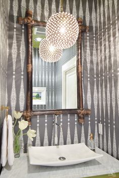 a white sink sitting under a bathroom mirror next to a wall mounted faucet