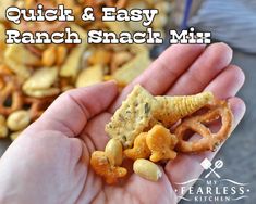 a hand holding a cracker and some food in it with the words quick & easy ranch snack mix