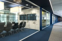 an empty conference room with glass walls and chairs