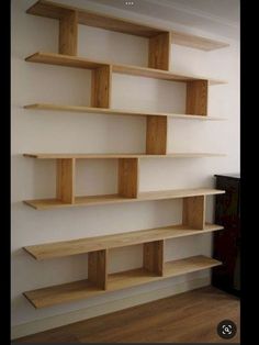 an empty room with some wooden shelves on the wall