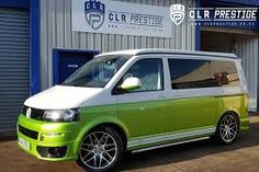 a green and white van parked in front of a building